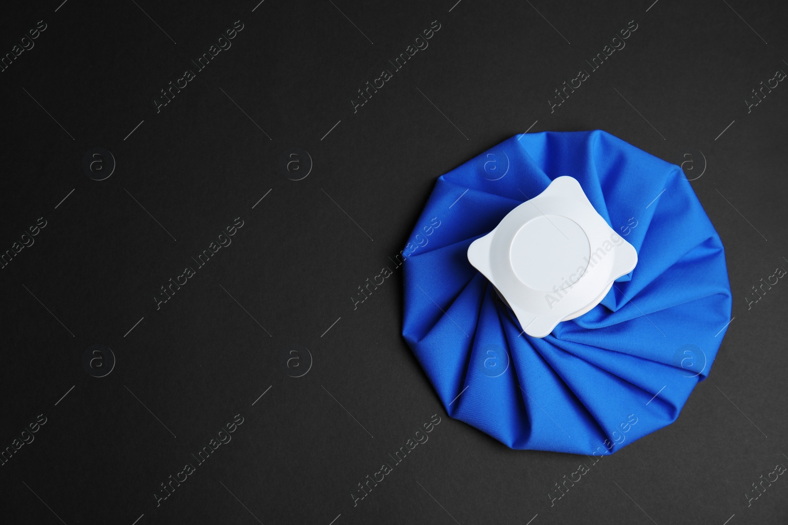 Photo of Ice pack on black background, top view. Space for text