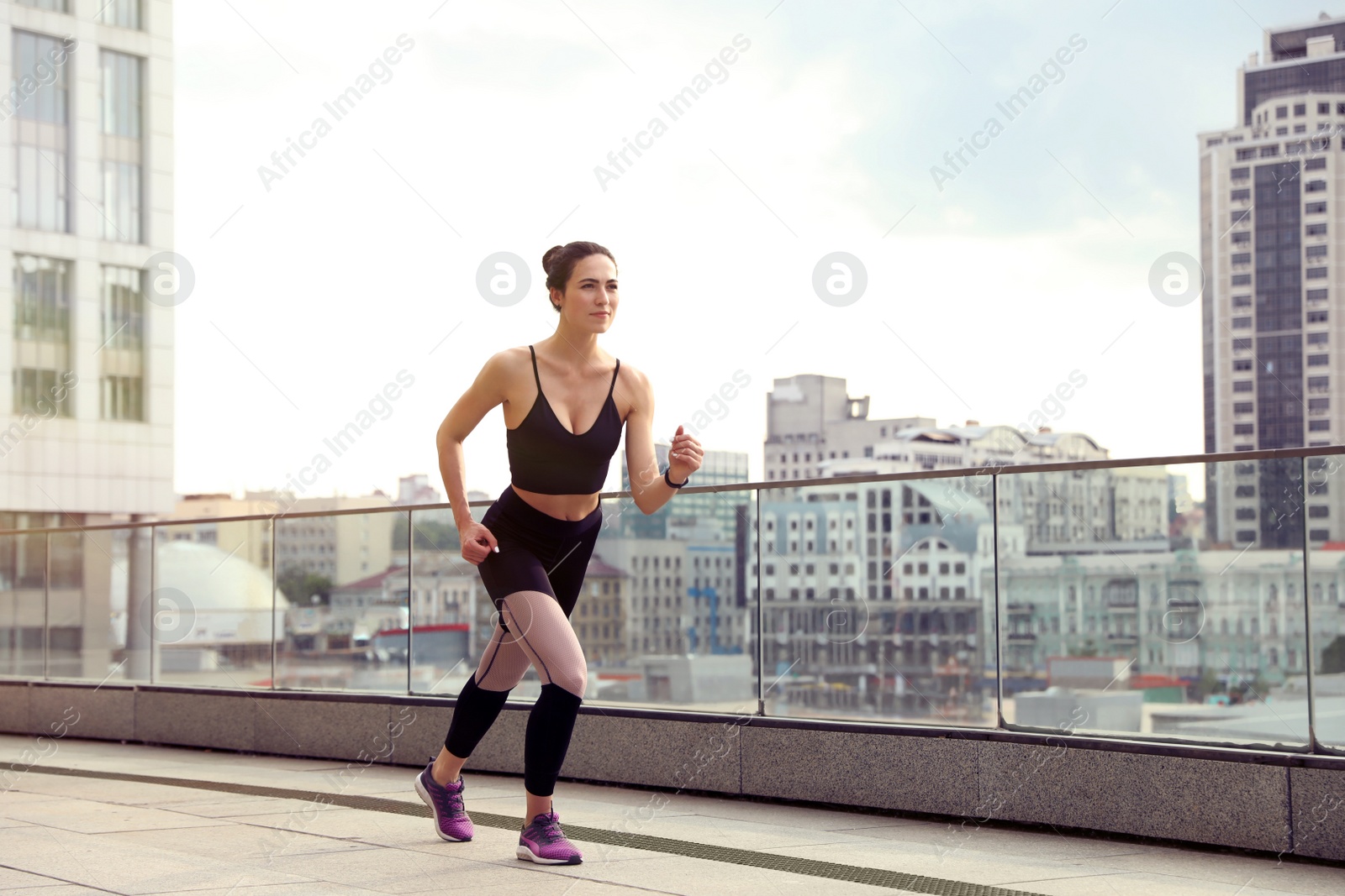 Photo of Beautiful sporty young woman running on street