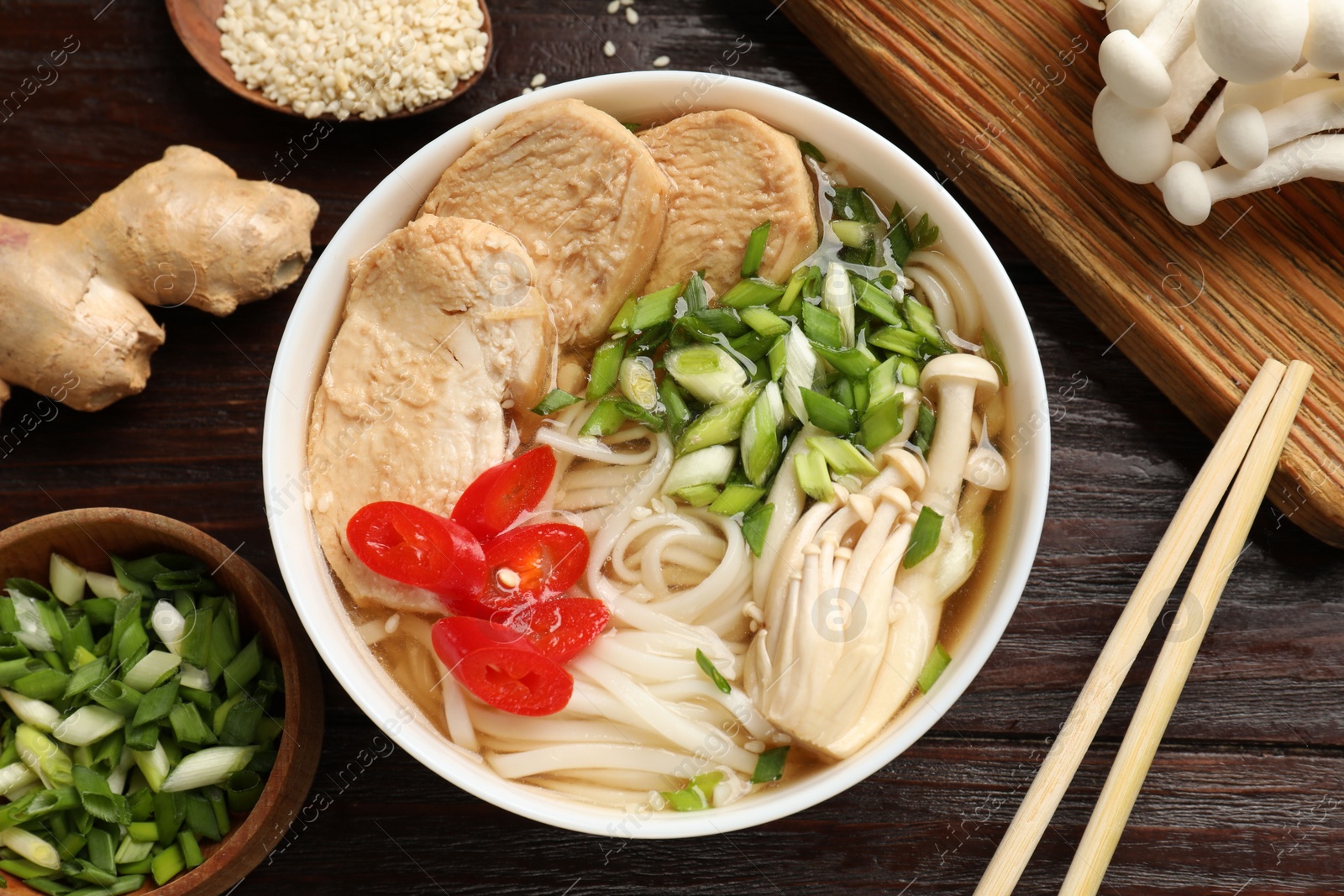 Photo of Delicious ramen with meat and ingredients on wooden table, flat lay. Noodle soup