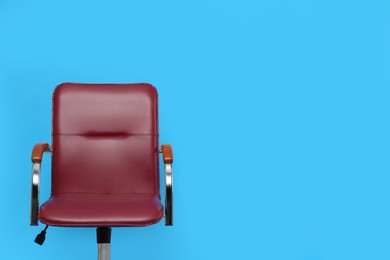 Comfortable office chair on light blue background, space for text
