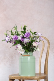 Photo of Vase with bouquet of beautiful flowers on chair against color background. Space for text