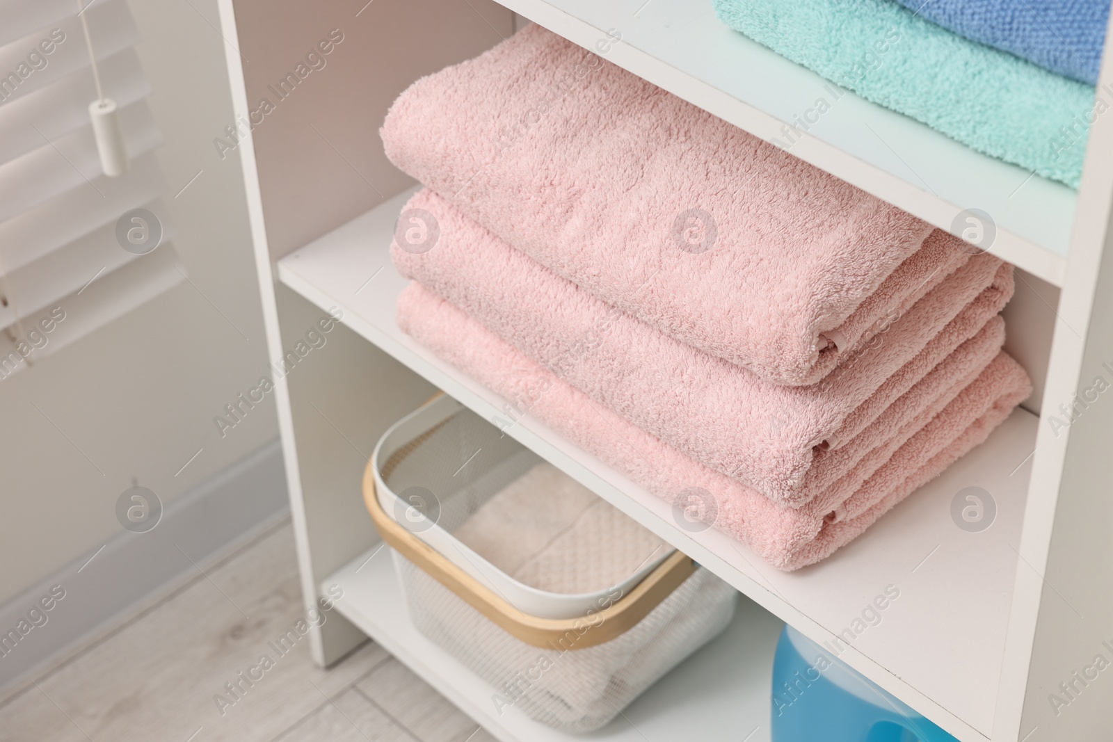 Photo of Stacked fesh towels and toiletries on shelf indoors, above view