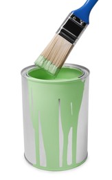 Photo of Can with light green paint and brush on white background