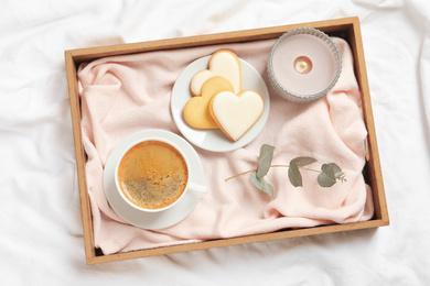 Aromatic coffee and cookies on bed, flat lay. Romantic breakfast