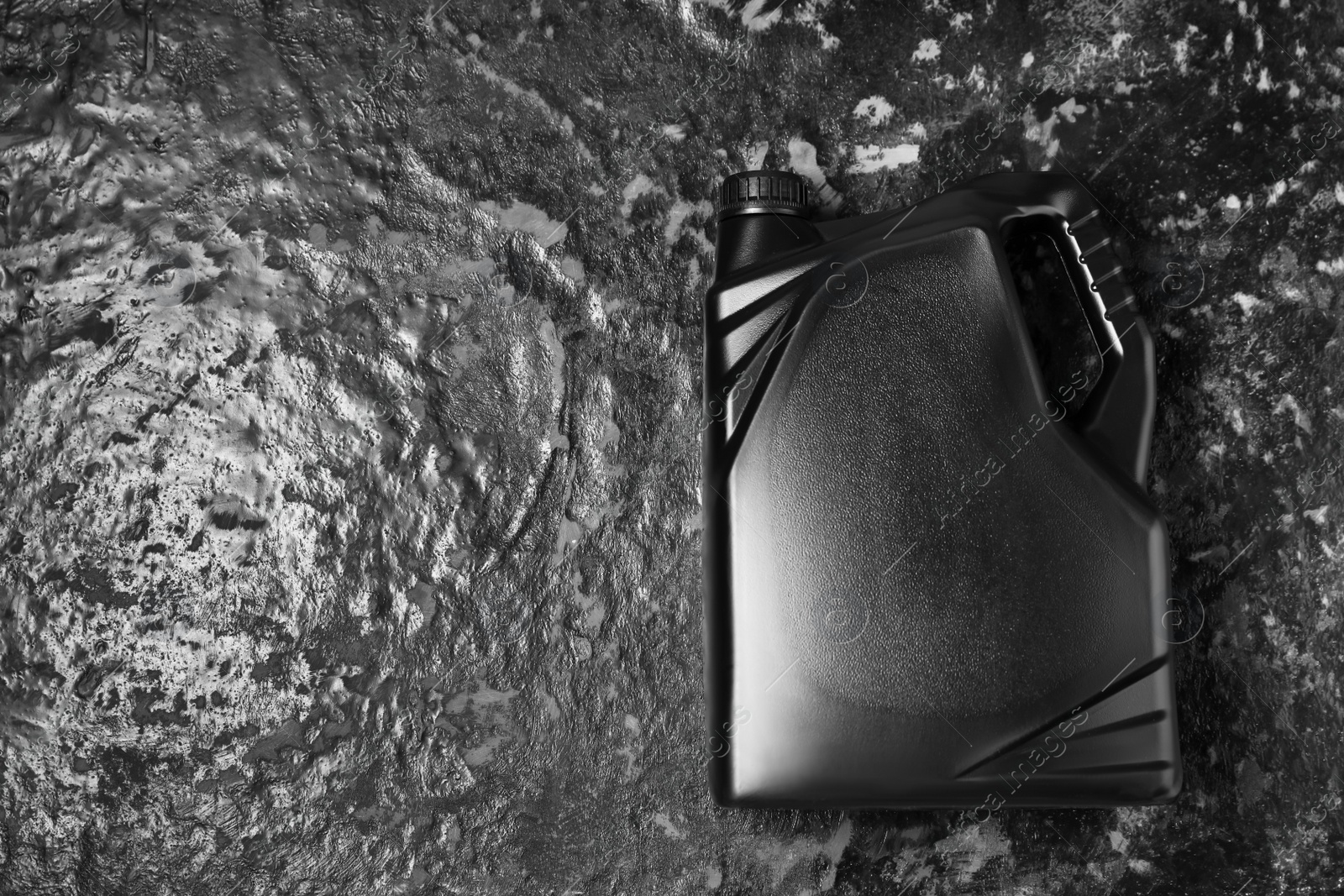 Photo of Motor oil in black canister on dark table, top view. Space for text