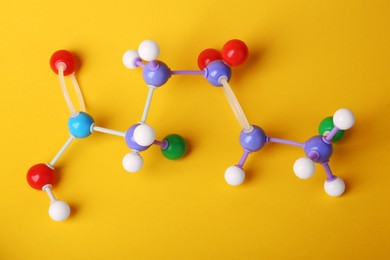 Structure of molecule on yellow background, top view. Chemical model