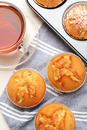 Photo of Flat lay composition with tasty muffins and tea on white wooden table