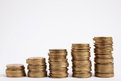 Many golden coins stacked on white background