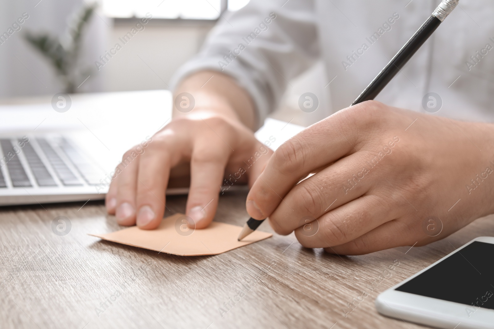 Photo of Young man working at desk in home office, closeup