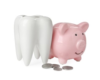 Photo of Ceramic model of tooth, piggy bank and coins on white background. Expensive treatment