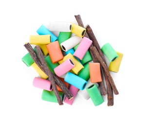 Photo of Many tasty candies and dried sticks of liquorice root isolated on white, top view