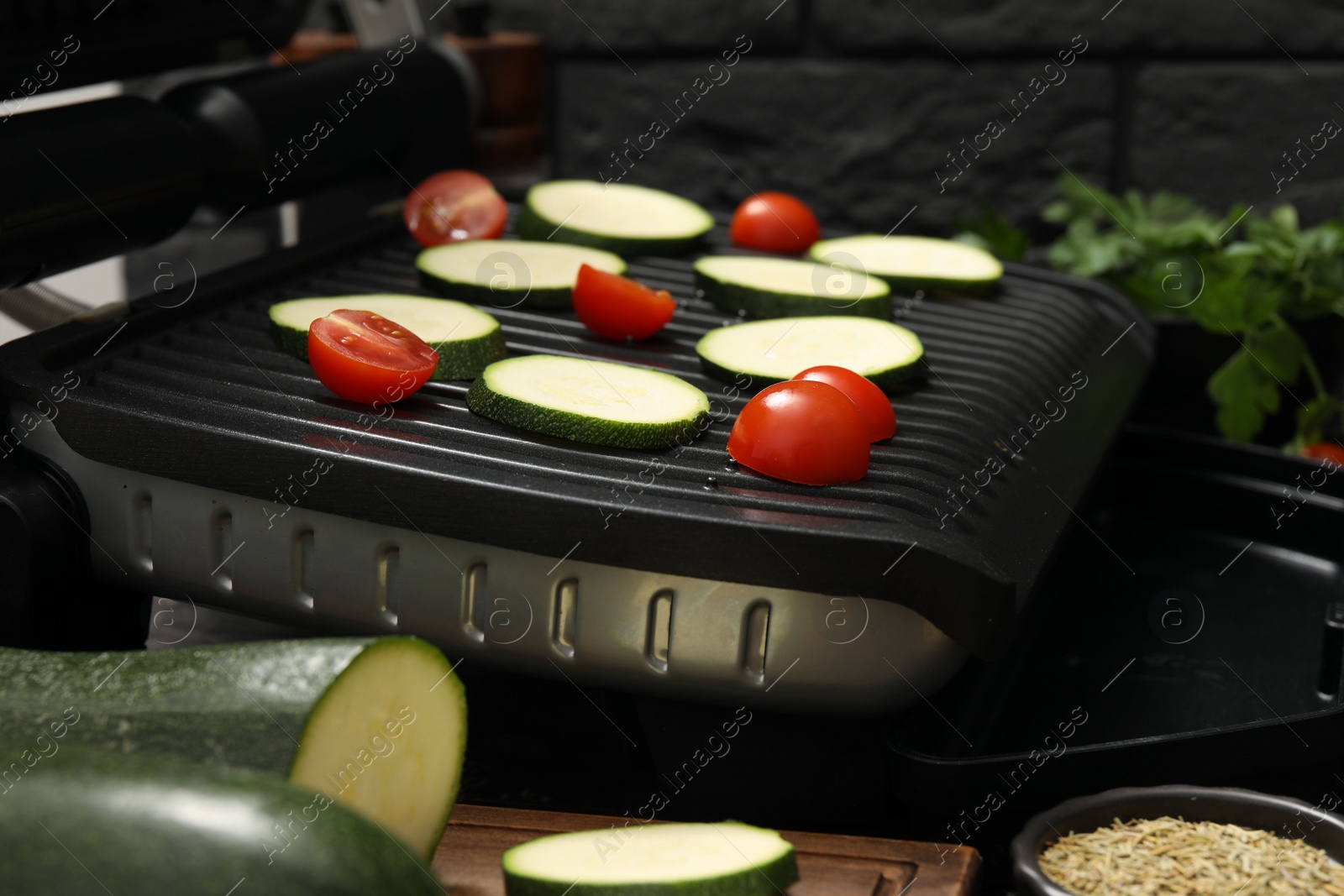 Photo of Electric grill with vegetables on table, closeup