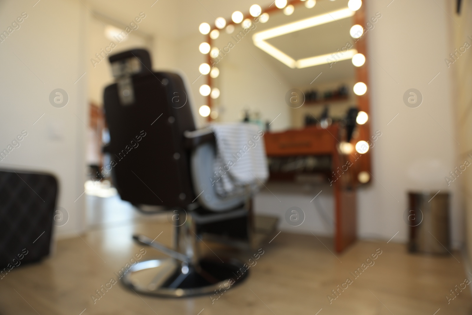 Photo of Blurred view of stylish barbershop interior with hairdresser workplace