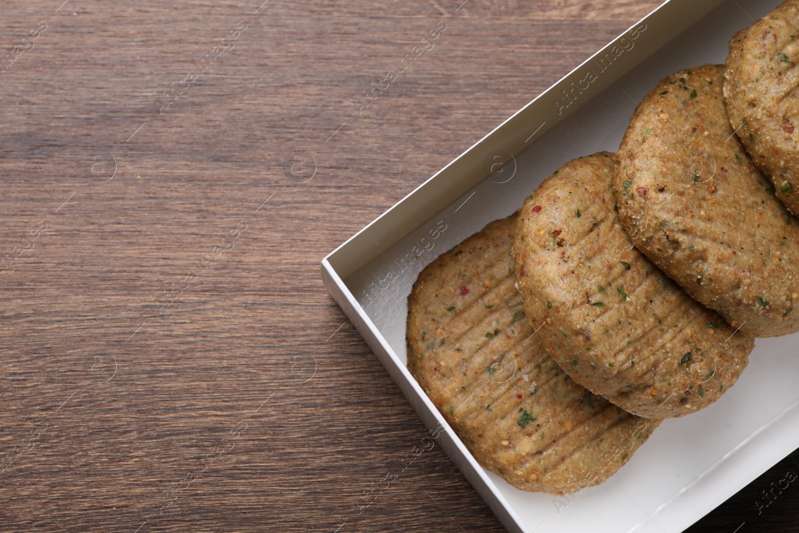 Photo of Tasty vegan cutlets on wooden table, top view. Space for text