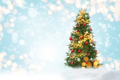 Image of Beautiful decorated Christmas tree on light blue background, space for text. Bokeh effect