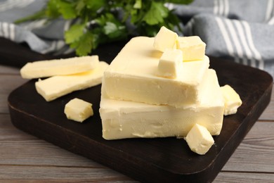 Photo of Pieces of tasty butter on wooden table