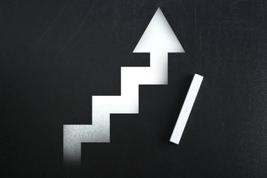 Image of Stairs with up arrow drawn on chalkboard, top view. Steps to success