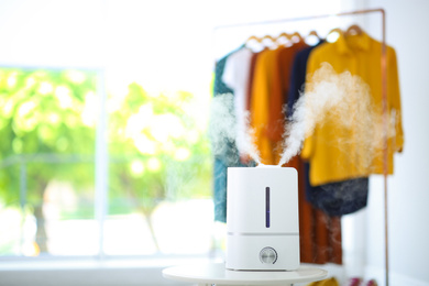 Modern air humidifier on table indoors. Space for text