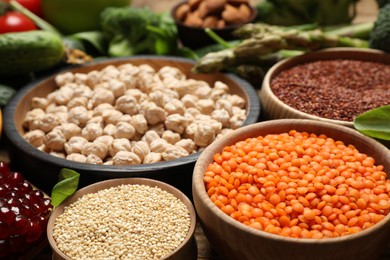 Photo of Fresh pomegranate, seeds and vegetables on table, closeup