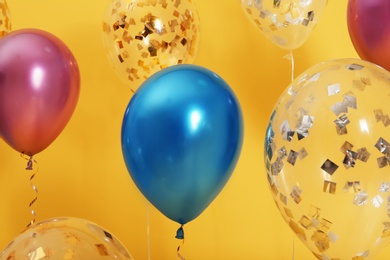 Photo of Bright balloons with ribbons on color background