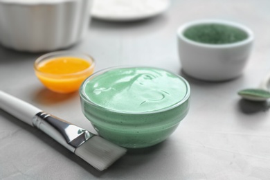 Photo of Freshly made spirulina in bowl and brush on light grey table