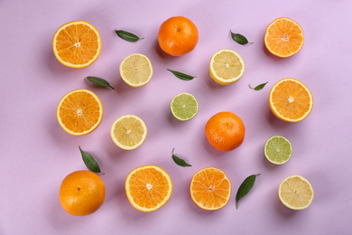 Flat lay composition with tangerines and different citrus fruits on lilac background