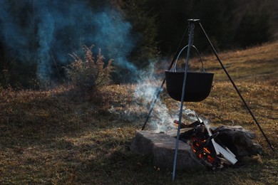 Photo of Cooking food on campfire near forest. Camping season