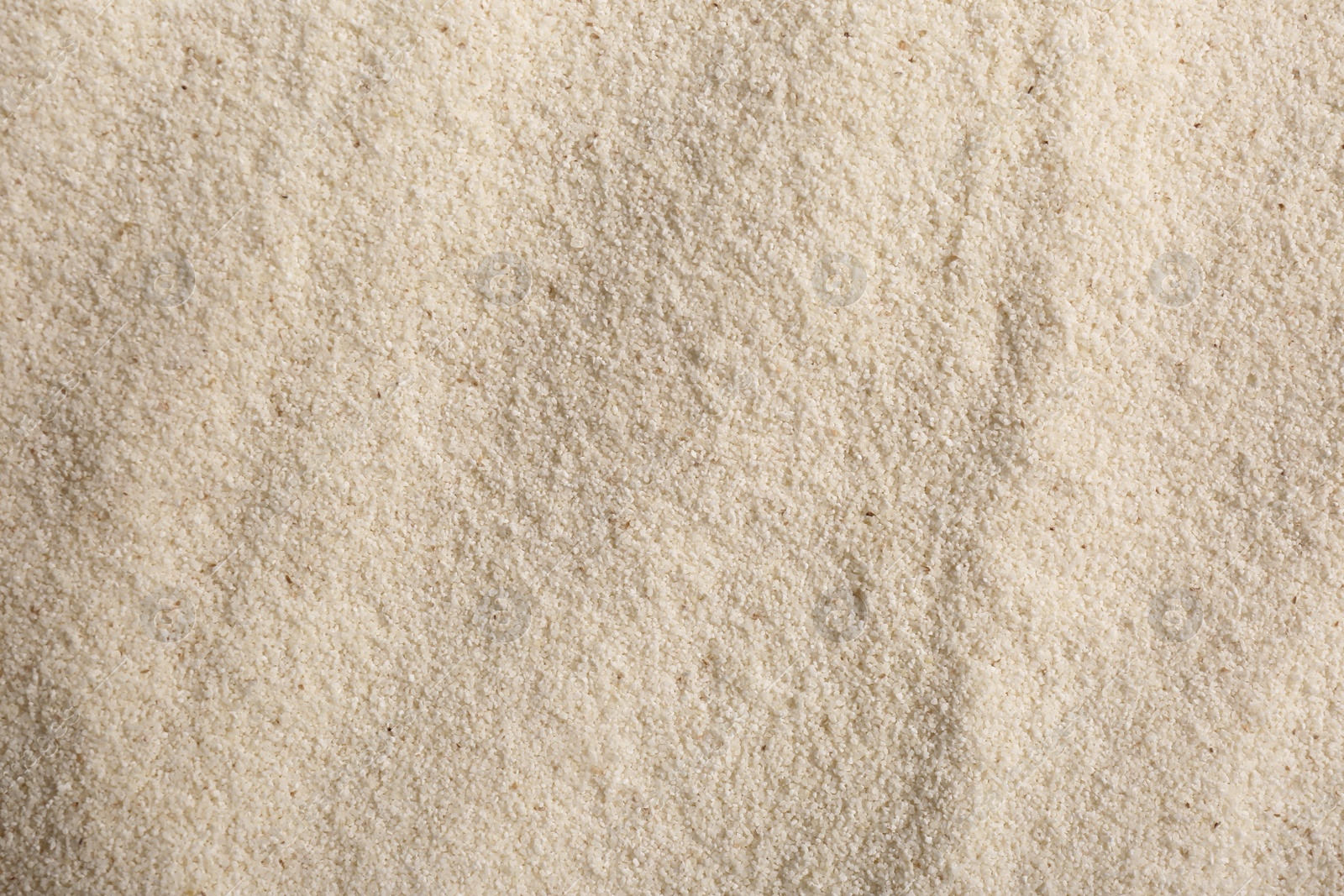 Photo of Uncooked organic semolina as background, closeup view