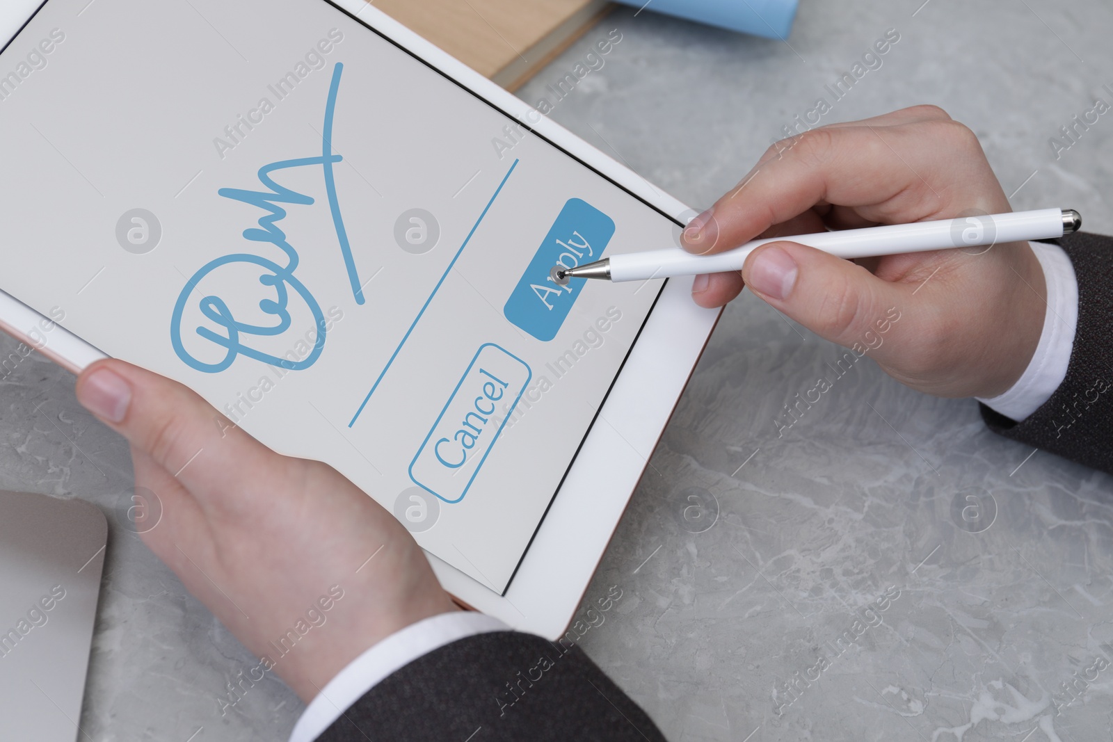 Image of Electronic signature. Man using stylus and tablet at table, closeup