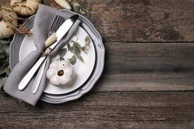 Photo of Festive table setting with autumn decor on wooden background, flat lay. Space for text
