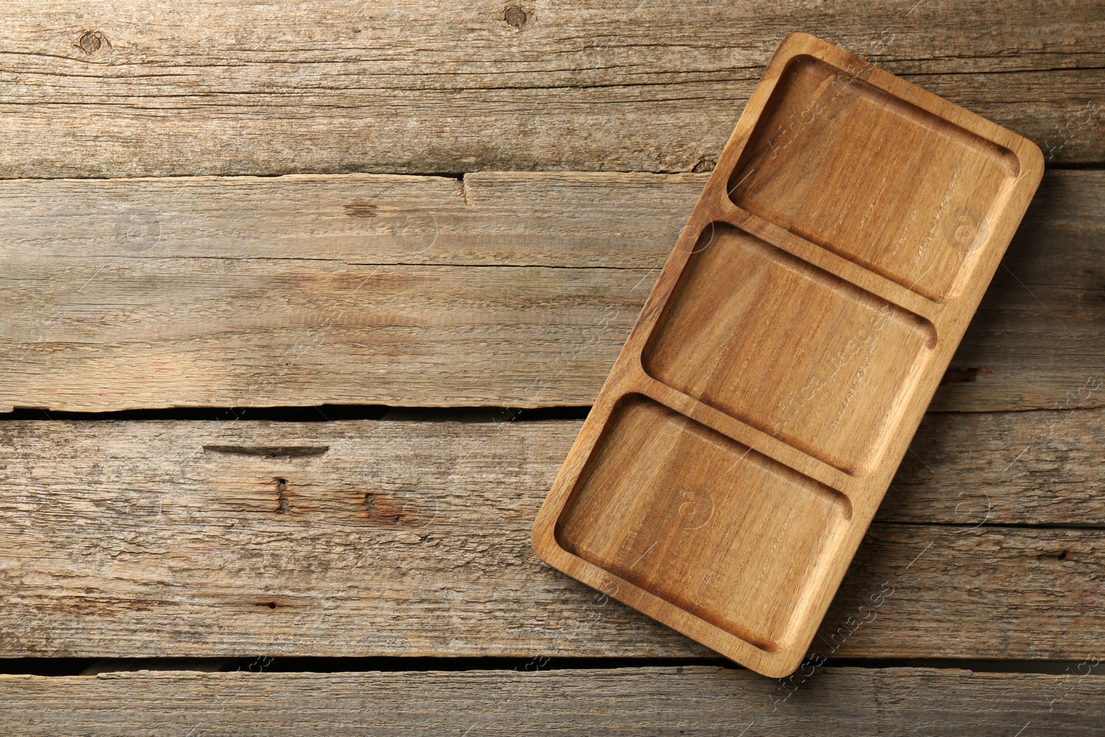 Photo of New compartment tray on old wooden table, top view. Space for text