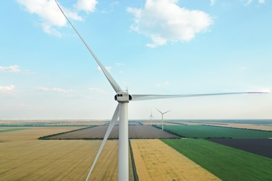 Photo of Modern windmill in wide field. Energy efficiency