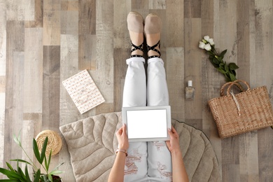 Woman with tablet sitting on floor, top view. Fashion blogger