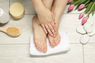 Photo of Closeup of woman with neat toenails after pedicure procedure on light background, top view