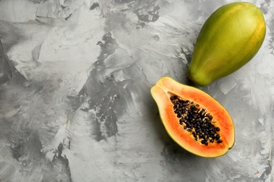 Photo of Fresh ripe papaya fruits on grey table, flat lay. Space for text