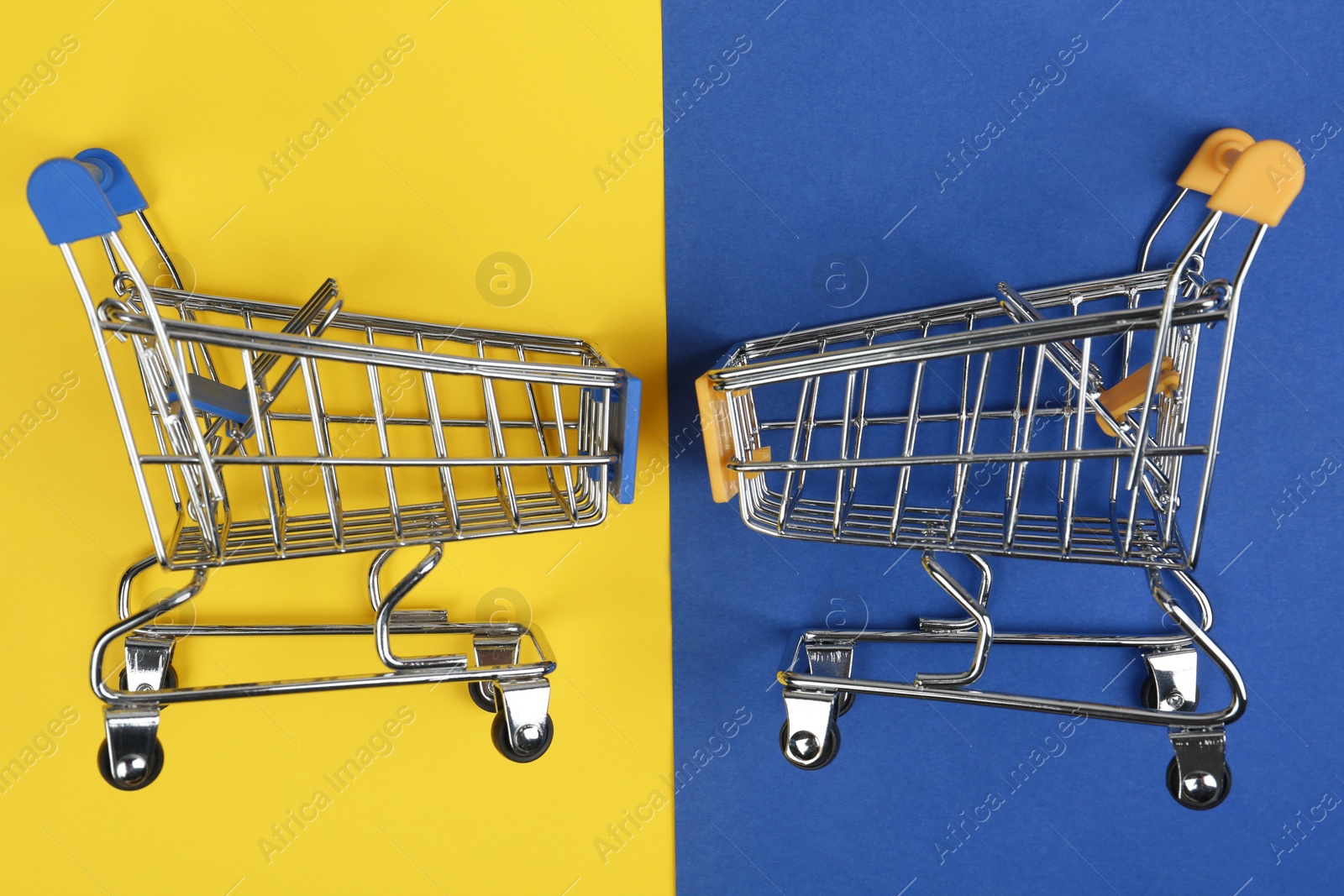 Photo of Flat lay composition with empty shopping trolleys on color background