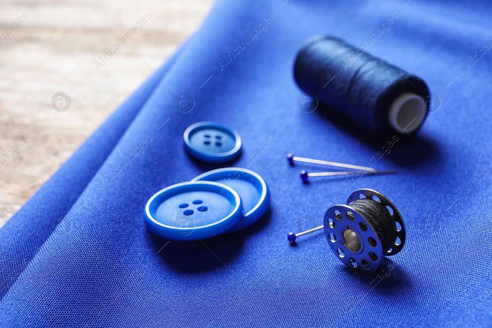 Photo of Set of tailoring accessories on blue fabric