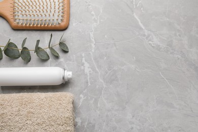Photo of Dry shampoo spray, hairbrush, towel and eucalyptus on light marble grey table, flat lay. Space for text