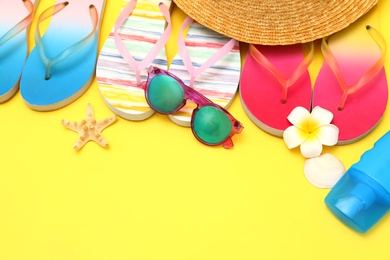 Photo of Set of different summer beach accessories on yellow background. Space for text