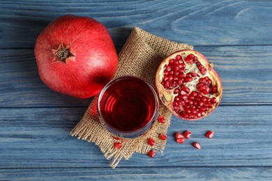 Glass of pomegranate juice and fresh fruits on wooden background, top view