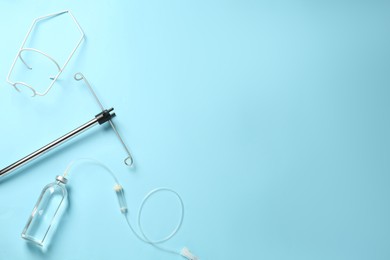 IV infusion set on light blue background, flat lay. Space for text