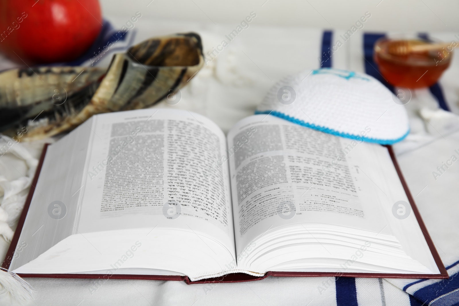 Photo of Open Torah, kippah and shofar on fabric, closeup. Rosh Hashanah celebration