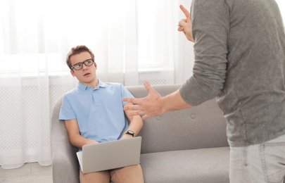 Photo of Father scolding his teenager son at home