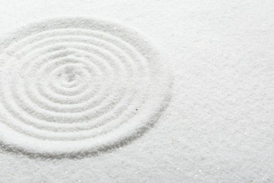 Photo of Zen rock garden. Circle pattern on white sand