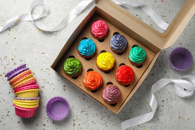 Photo of Flat lay composition with delicious colorful cupcakes on light grey table