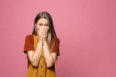 Happy teenage girl on pink background. Space for text