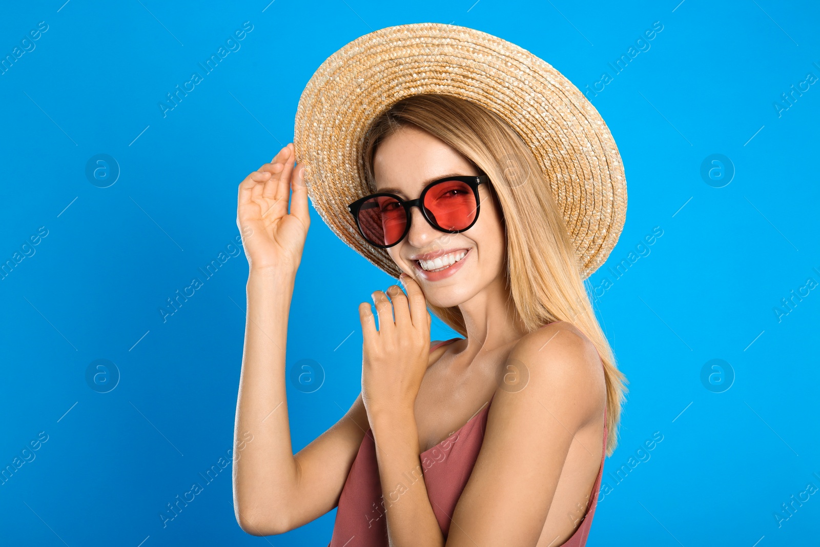 Photo of Beautiful woman in stylish sunglasses on light blue background