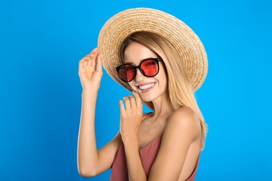 Beautiful woman in stylish sunglasses on light blue background