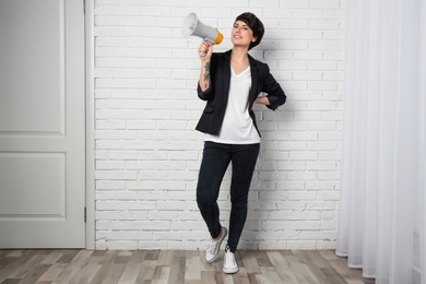 Photo of Young woman with megaphone indoors