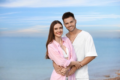 Photo of Young woman in bikini with her boyfriend on beach, space for text. Lovely couple